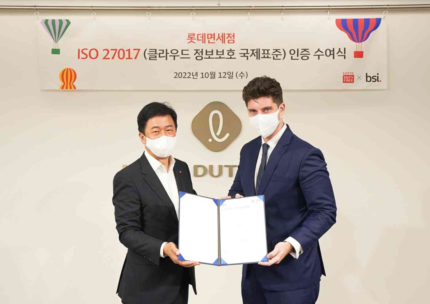 12일 서울 중구 롯데면세점 본사에서 열린 ISO 27017 인증 수여식에서 (왼쪽)이갑 롯데면세점 대표이사와 톰 헬름 주한 영국대사관 서기관(오른쪽)이 기념촬영을 하고 있는 모습(롯데면세점 제공).